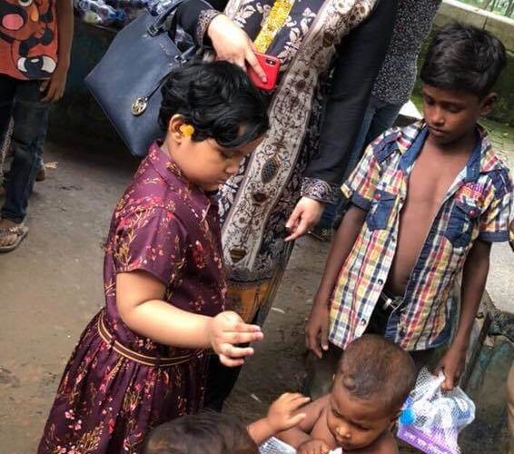 Dr. Purabi and her daughter is distributing food among the poor children